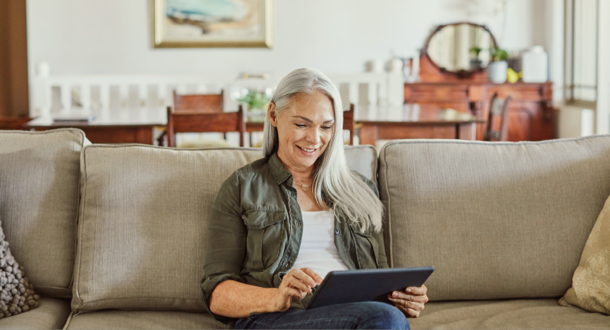 woman on couch reading tablet