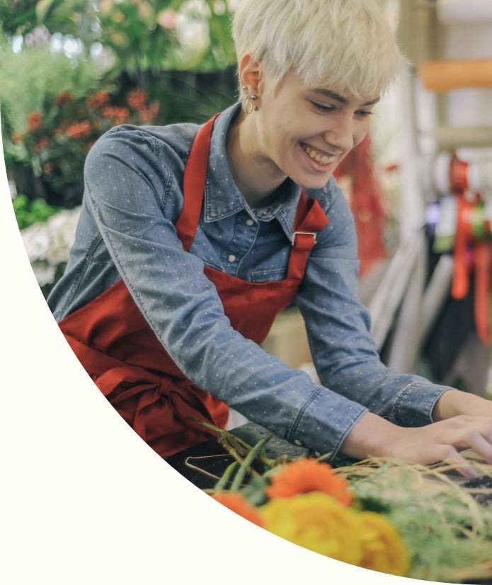 young female working on laptop at florist shop