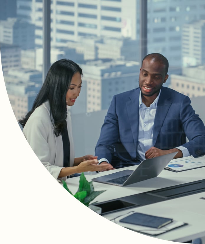 two business professionals having a meeting and looking at a laptop