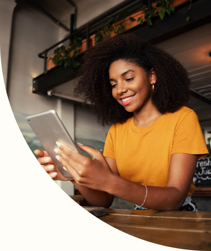 African American woman using digital tablet sitting at coffee shop